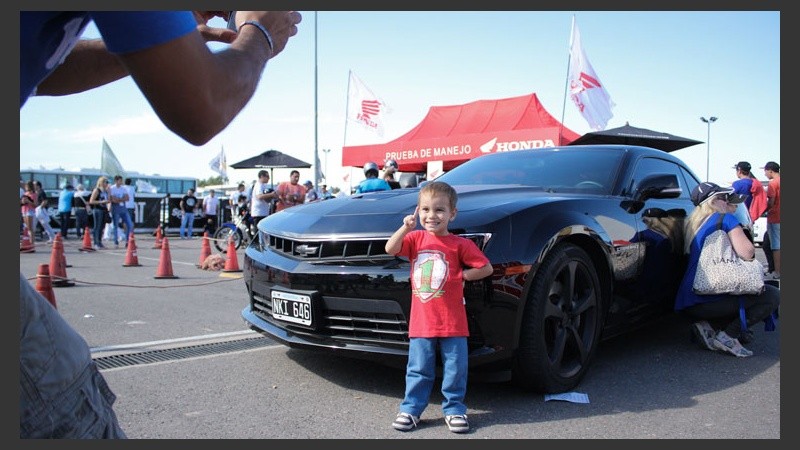 Un niño se saca una foto con otro de los Camaro que había entre el público.