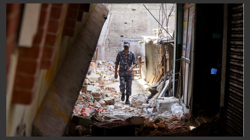 Un soldado nepalí camina entre los restos de edificios destrozados. 