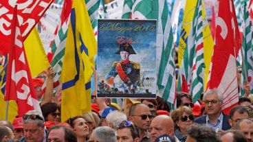 Estudiantes sostienen una pancarta en la que se puede leer "E5 de mayo de 2015, él fue..." con una imagen del primer ministro italiano vestido de Napoleón.