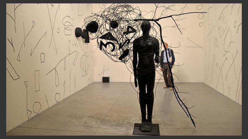Un hombre contempla una obra del artista italiano Mimmo Paladino.