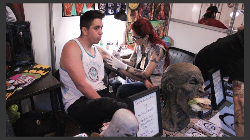 Una mujer dibuja el brazo de un chico.