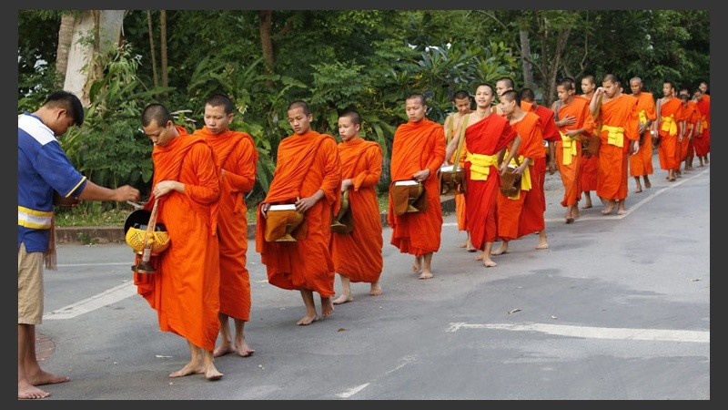 Los budistas forman una larga fila, y  descalzos, comienzan la caminata al norte del país asiático.