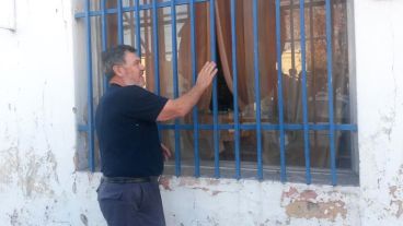 Alberto Perassi mostrando los daños en una de las ventanas.