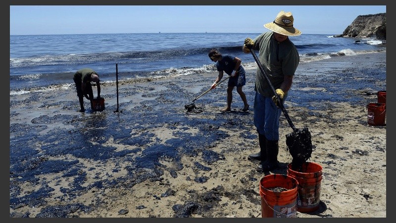 Voluntarios limpian una playa de la costa de California por derrame de petróleo.