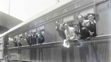 Muestra "Llévame a ver un tren": Jóvenes posan desde el interior de un coche comedor. Colección Chiavazza. Escuela de Museología.
