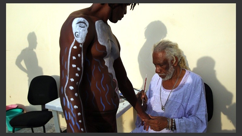 El pintor trabaja en el cuerpo de uno de los hombres.