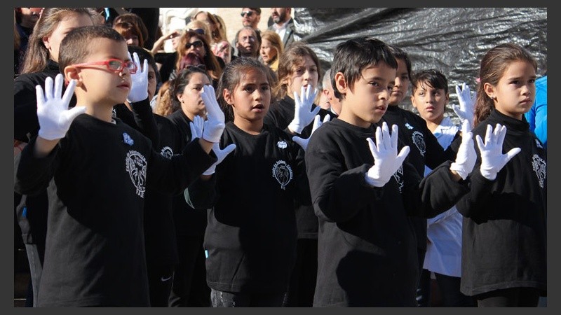 Chicos interpretan el himno nacional en lenguaje de señas.