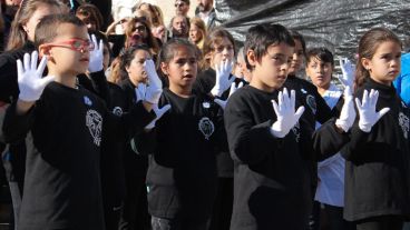 Chicos interpretan el himno nacional en lenguaje de señas.