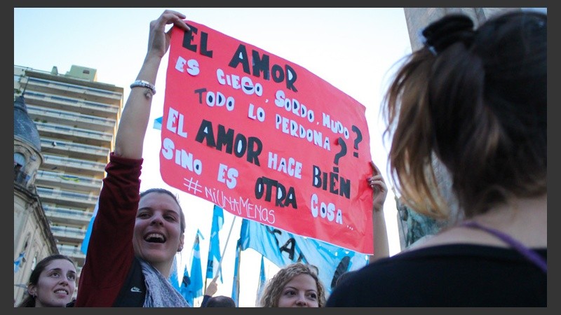 Dos mujeres sostienen un cartel en cercanías al Monumento.