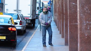 Un hombre sufre del frío en una parada de taxis este jueves en San Martín y San Juan.