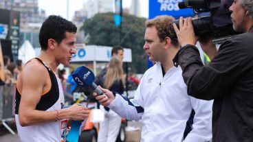 El equipo de El Tres entrevistando al primero en llegar de los 8Km. (Alan Monzón/Rosario3.com)