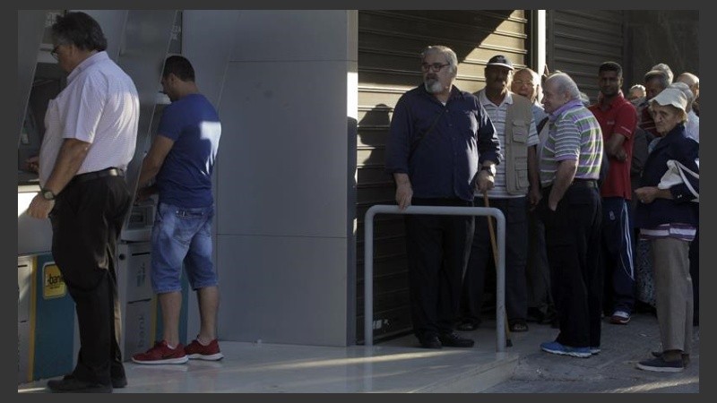 Una larga cola este lunes en loa cajeros automáticos del Banco Nacional en Atenas. 