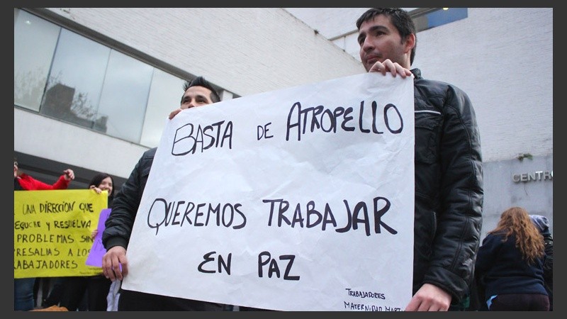 Dos hombres sostien un cartel este viernes al mediodía en Moreno y San Luis. (Rosario3.com)