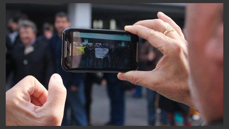 Un hombre toma una foto al grupo de manifestantes frente a la Maternidad Martin. (Rosario3.com)