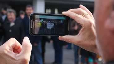 Un hombre toma una foto al grupo de manifestantes frente a la Maternidad Martin. (Rosario3.com)