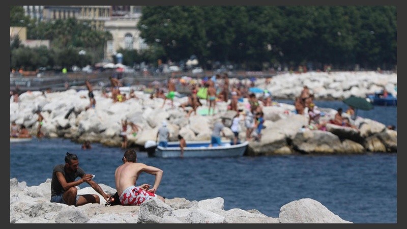 Como contrapunto de lo que sucede en nuestra región, en Nápoles varias personas toman sol en una tarde de calor. (EFE)