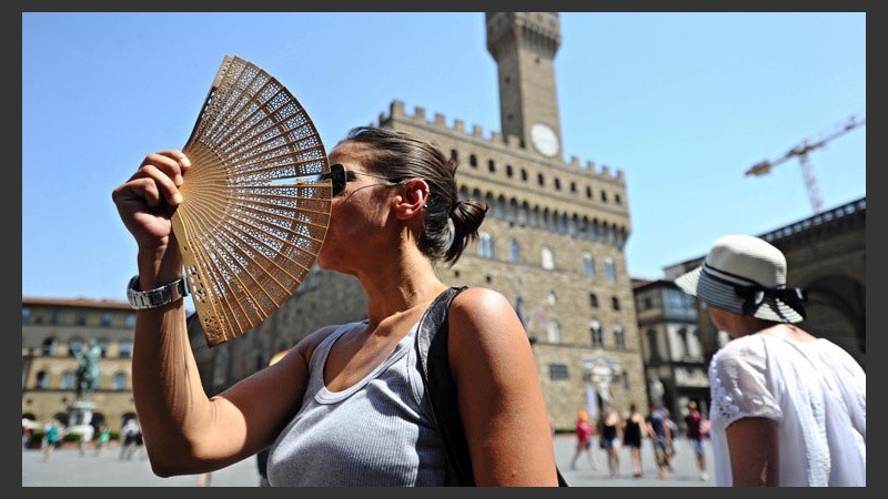 Una mujer usa un abanico para combatir el calor en una calle de Florencia, Italia. (EFE)