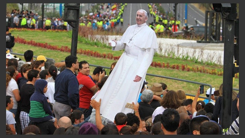 Fieles levantan una gigantografía del Papa a la espera de su paso. (EFE)