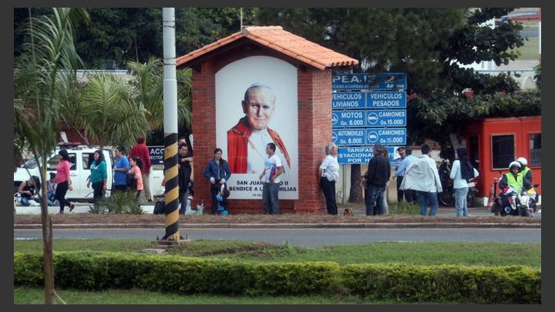 Una pintura con la cara de Juan Pablo II mientras la gente esperaba por Francisco en las calles de Asunción. (EFE)