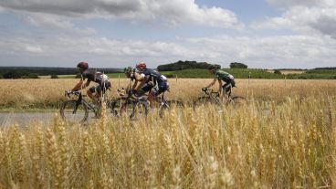 Un grupo de ciclistas pasan por los campos del poblado Mur De Bretagne al noroeste de Francia. (EFE)