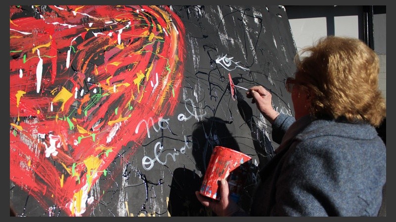 Una señora dibuja una lágrima. Había un mural donde cada uno podía dejar su mensaje. (Alan Monzón/Rosario3.com)