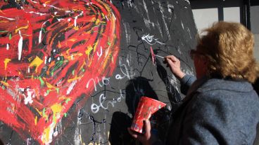 Una señora dibuja una lágrima. Había un mural donde cada uno podía dejar su mensaje. (Alan Monzón/Rosario3.com)