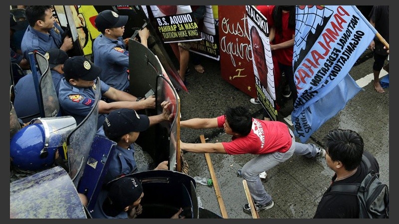 Duro cruce entre los manifestantes con la policía en la ciudad de Manila este lunes. (EFE)