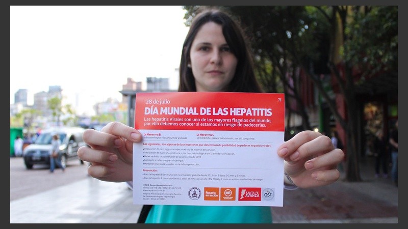 Una chica muestra un folleto en el Día Mundial contra las Hepatitis. (Rosario3.com)