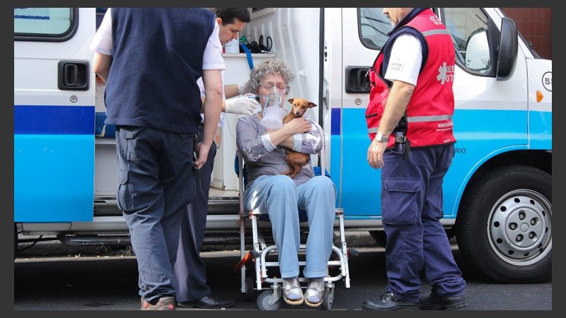 Una señora junto a su perro recibiendo asistencia.