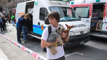 Un joven con sus perros en mano tras sacarlos del edificio.