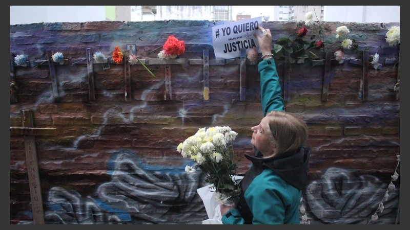 Una señora pone un cartel en el lugar de la tragedia.