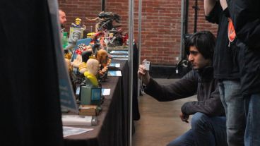 Un joven le saca una foto a uno de los muñecos artesanales. (Rosario3.com)