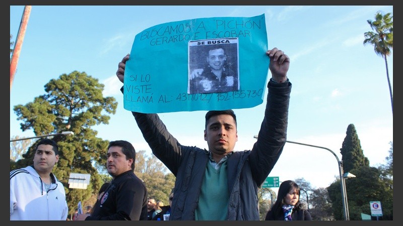 Un hombre sostiene un cartel durante la marcha en Oroño y Pellegrini.