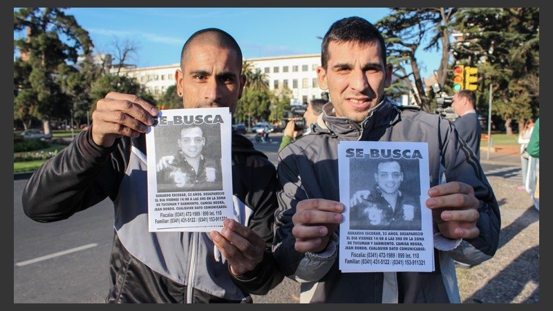 Dos chicos posan ante cámara mostrando los folletos. (Alan Monzón/Rosario3.com)