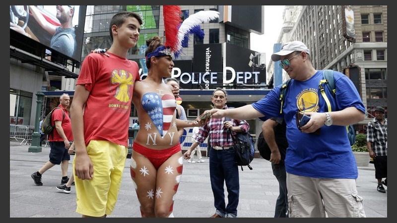 Pintura en el cuerpo y un paseo con poca ropa para llamar la atención en pleno Times Square en Nueva York. (EFE)