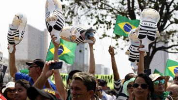 Un grupo de brasileños levantan muñecos del expresidente Lula da Silva mientras protestan contra la presidenta Dilma Rousseff durante el desfile militar. (EFE)