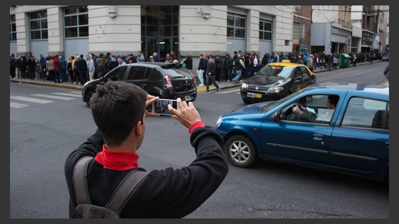 Un joven le saca fotos a la enorme cola. (Rosario3.com)