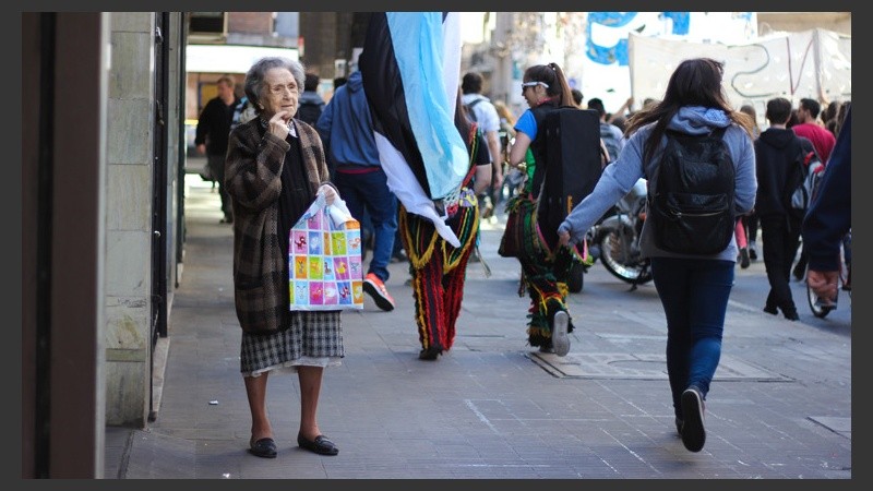Una señora observa pasar la columna de gente por calle San Lorenzo. (Alan Monzón/Rosario3.com)