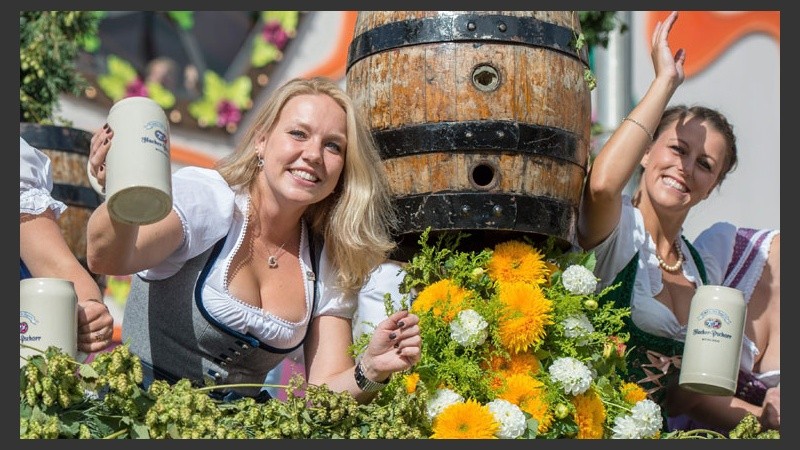Dos chicas alemanas con cerveza en mano posando para la cámara. (EFE)
