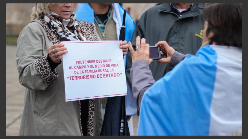 Una señora y un cartel para la foto.