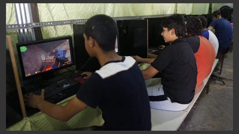 Para pasar el rato, niños juegan con la computadora. (EFE)
