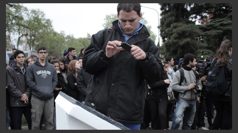 Un compañero de Escobar toma una foto a la placa. (Rosario3.com)