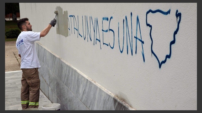 Un operario borra una pintada en el colegio electoral del Centro Cultural Mira-sol de San Cugat donde votó el cabeza de lista de Junts pel Sí. (EFE