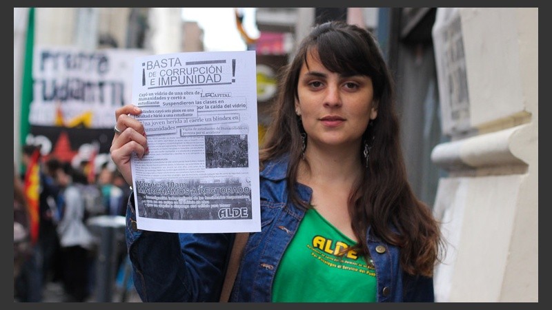 Una joven muestra uno de los folletos que se repartían por la calle. (Alan Monzón/Rosario3.com)