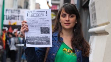 Una joven muestra uno de los folletos que se repartían por la calle. (Alan Monzón/Rosario3.com)