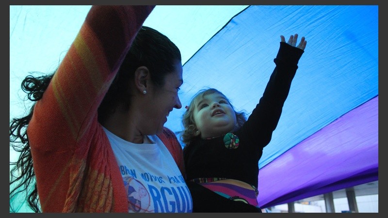 Una pequeña se esfuerza para tocar la bandera colorida. (Alan Monzón/Rosario3.com)