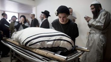 Una mujer junto a uno de los cuerpos durante el funeral judío en Jerusalén. (EFE)