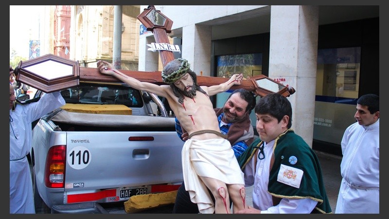 Dos hombres hacen fuerza para levantar la imagen de Jesús que se vio en la celebración. (Alan Monzón/Rosario3.com)