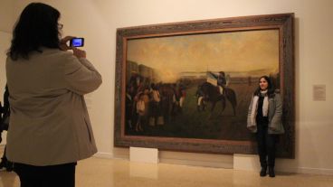 Una chica se saca una foto con un gran pintura en el Museo Histórico Provincial. (Rosario3.com)