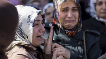 Familiares de una de las víctimas aseinadas en el doble atentado lloran sobre su ataúd durante el funeral en Estambul.